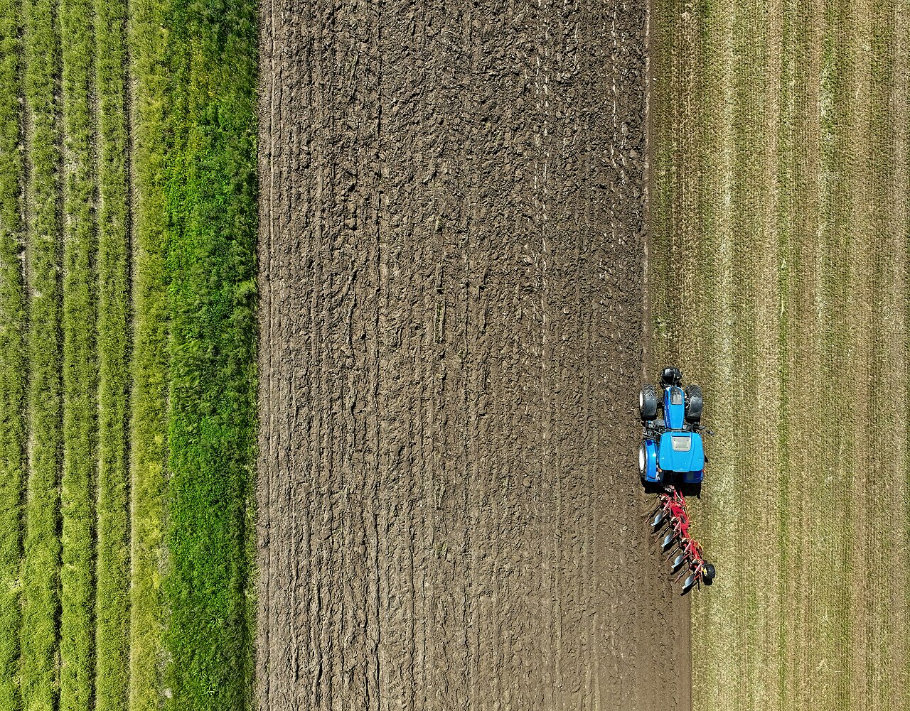 Tractor arando una parcela agrícola vista desde el aire